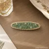 A simple and elegant hair accessory with a white floral hairpin and green crystal accents details Picture